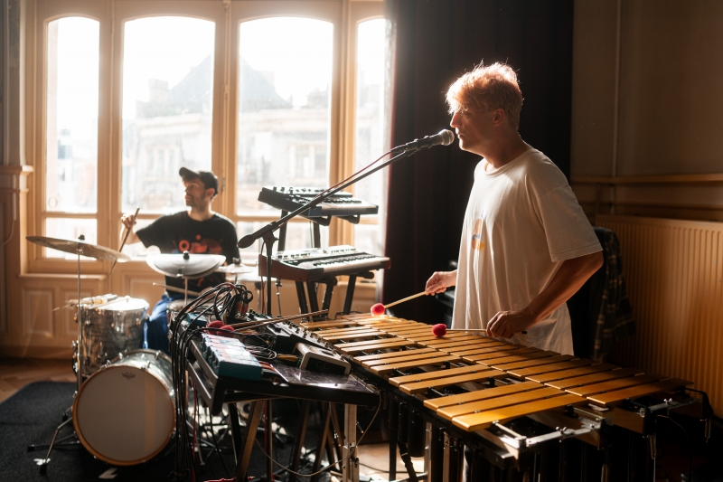 Foto van een muzikant met een keyboard en microfoon, en een muzikant met een drumstel, beeld van deze Open Dance Jam
