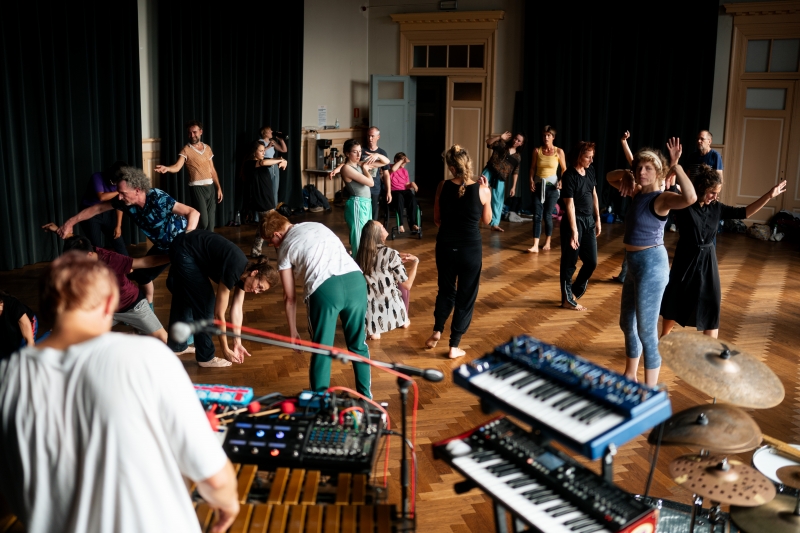 Foto van een groep dansende mensen met muzikant met keyboard en muzikant met drumstel op de voorgrond, beeld van deze Open Dance Jam
